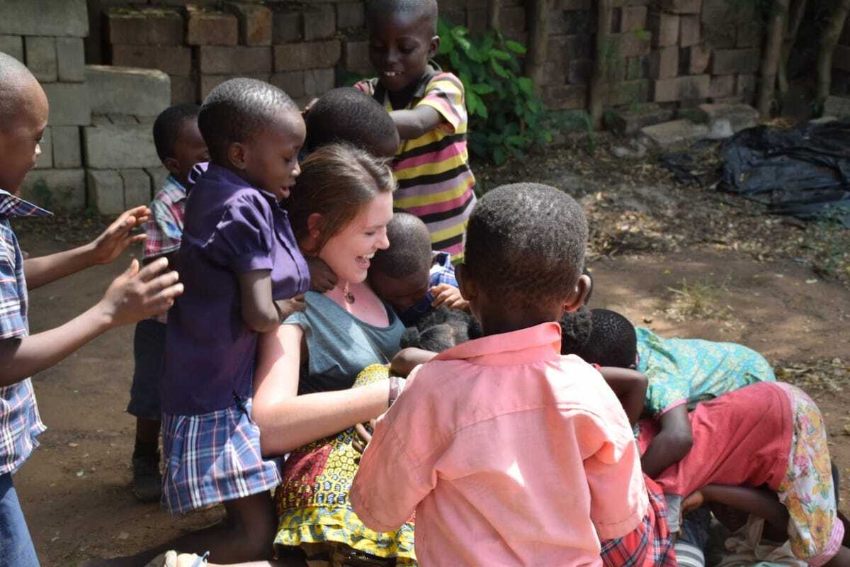 Volunteer tobt lachend mit afrikanischen Kindern